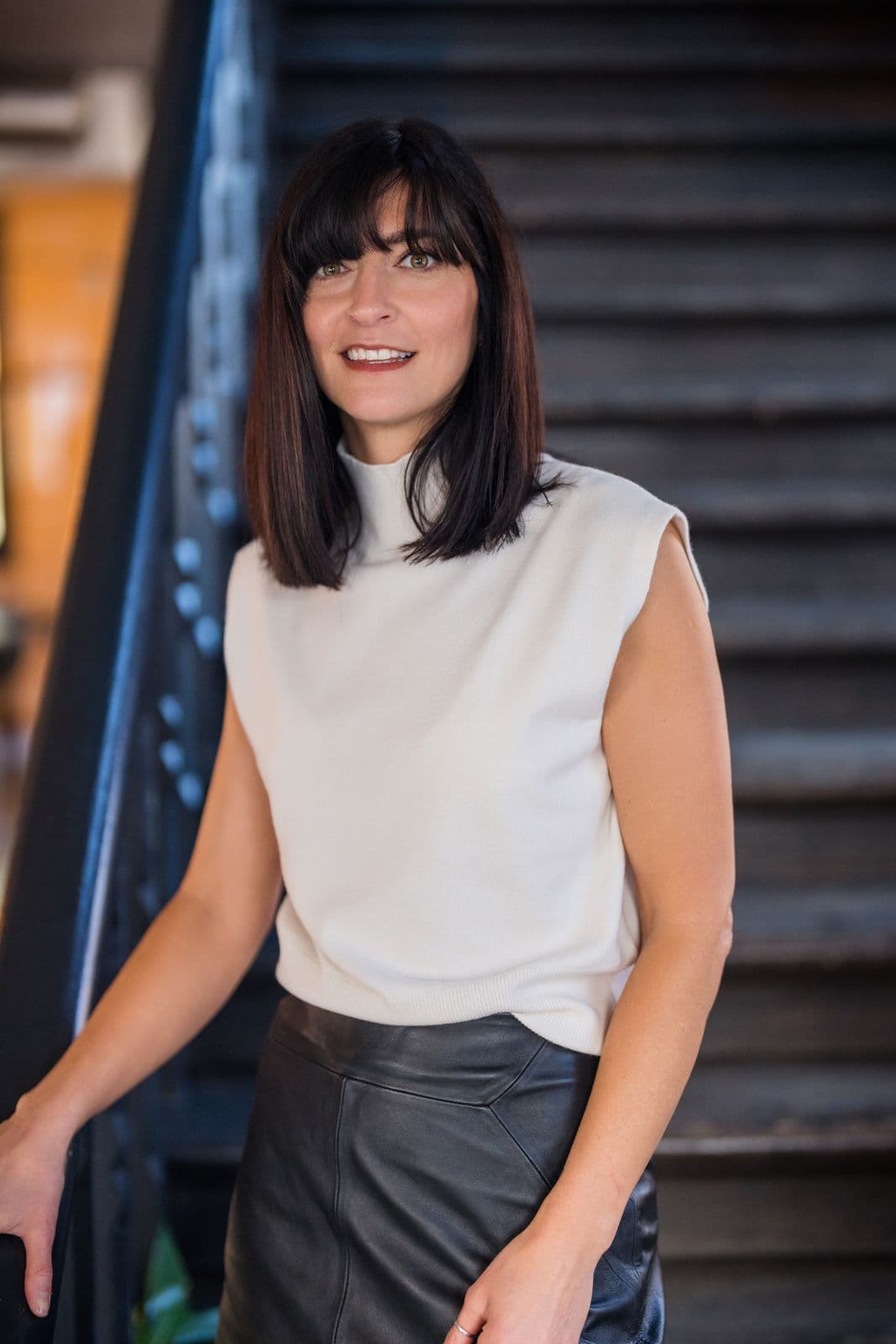 Katie Clarke on an industrial staircase, smiling at the camera