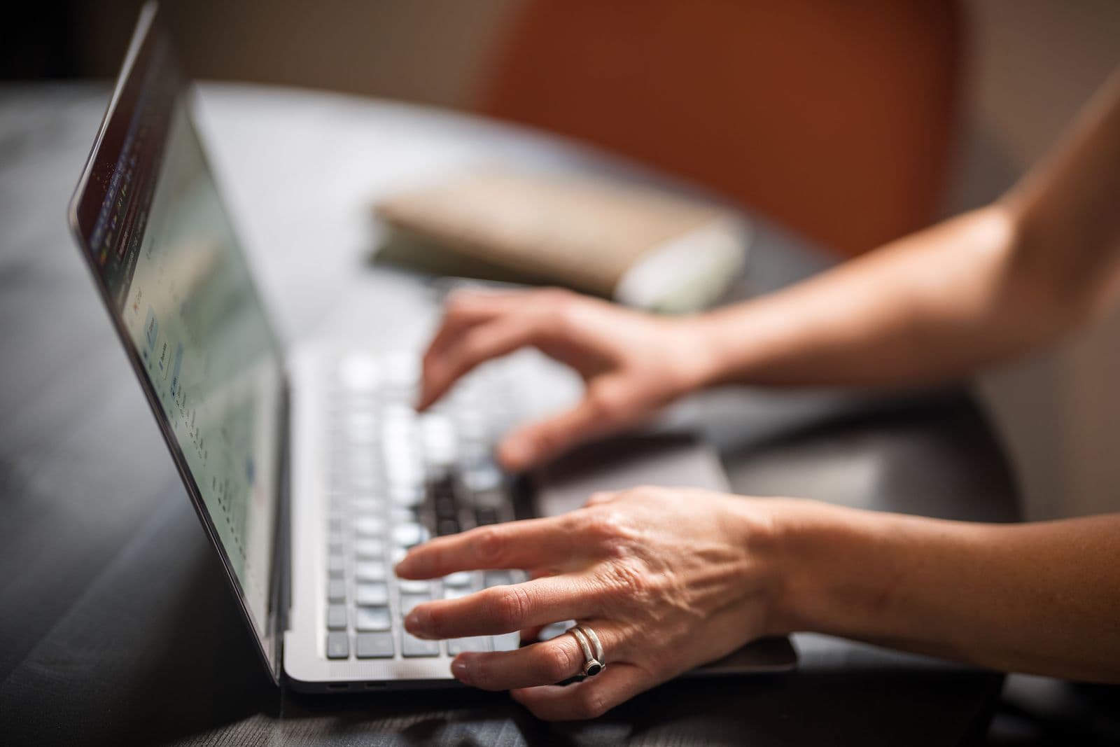 Hands typing on a laptop