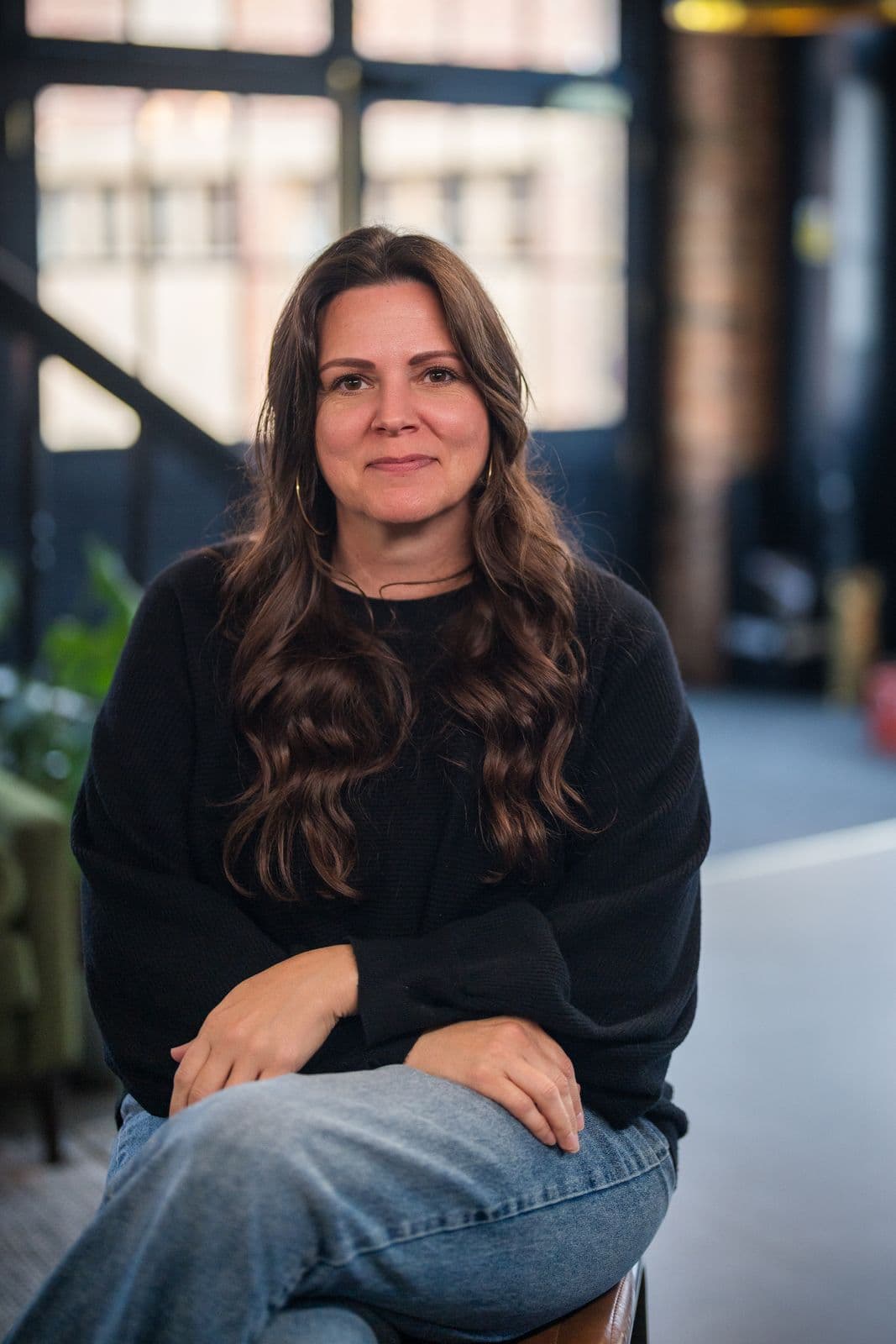 A woman with long dark hair, photographed on the Clic HQ filming day, September 2024