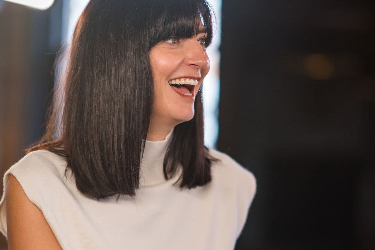 Katie Clarke laughing as she talks to someone off camera