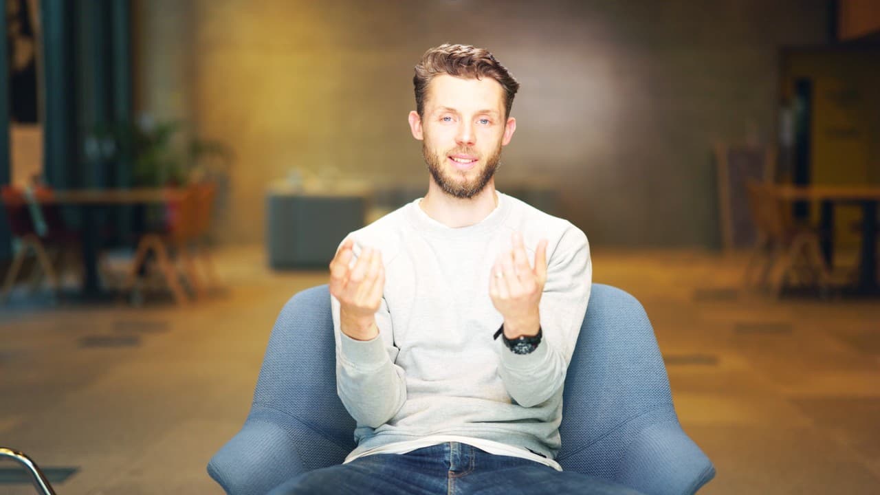 Jon in an armchair in the studio, talking to the camera