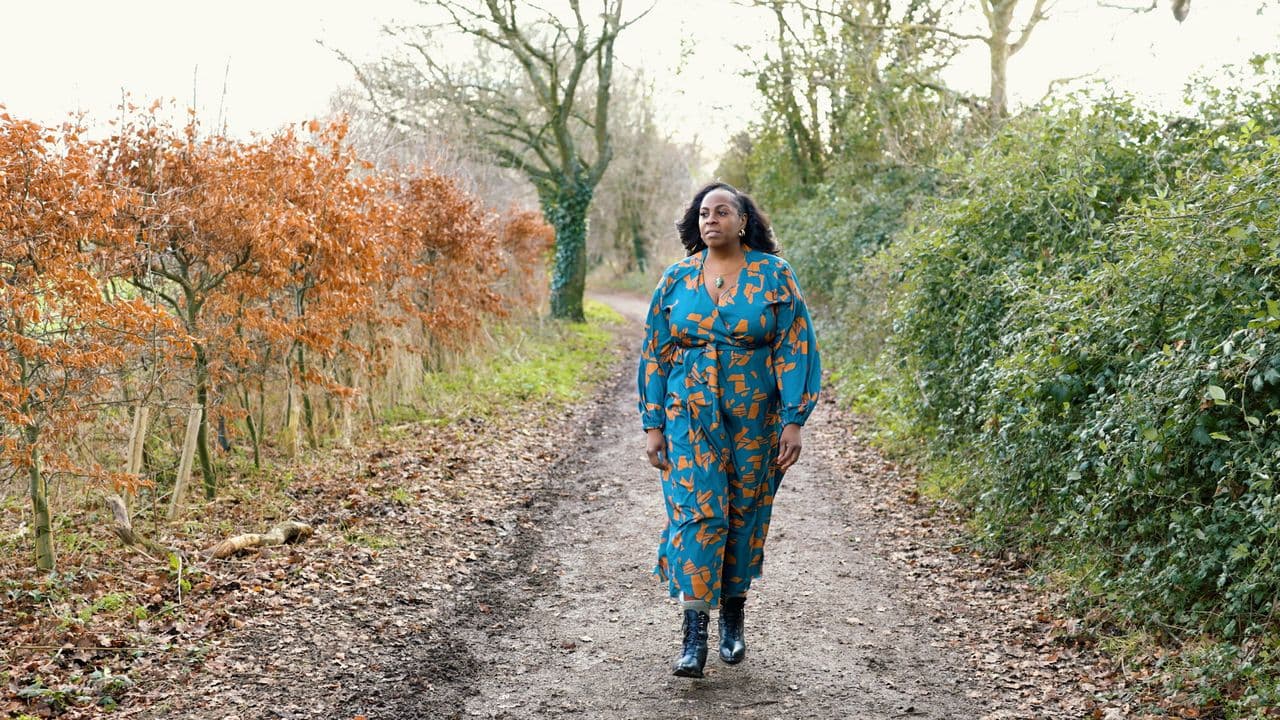 Mecca walking towards the camera down a forest track between copper beech hedges