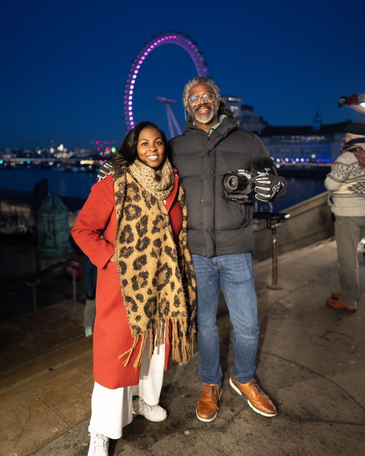 Kevan and Mecca Perry smiling at the camera on the South Bank at night, the London Eye lit behind them, January 2025