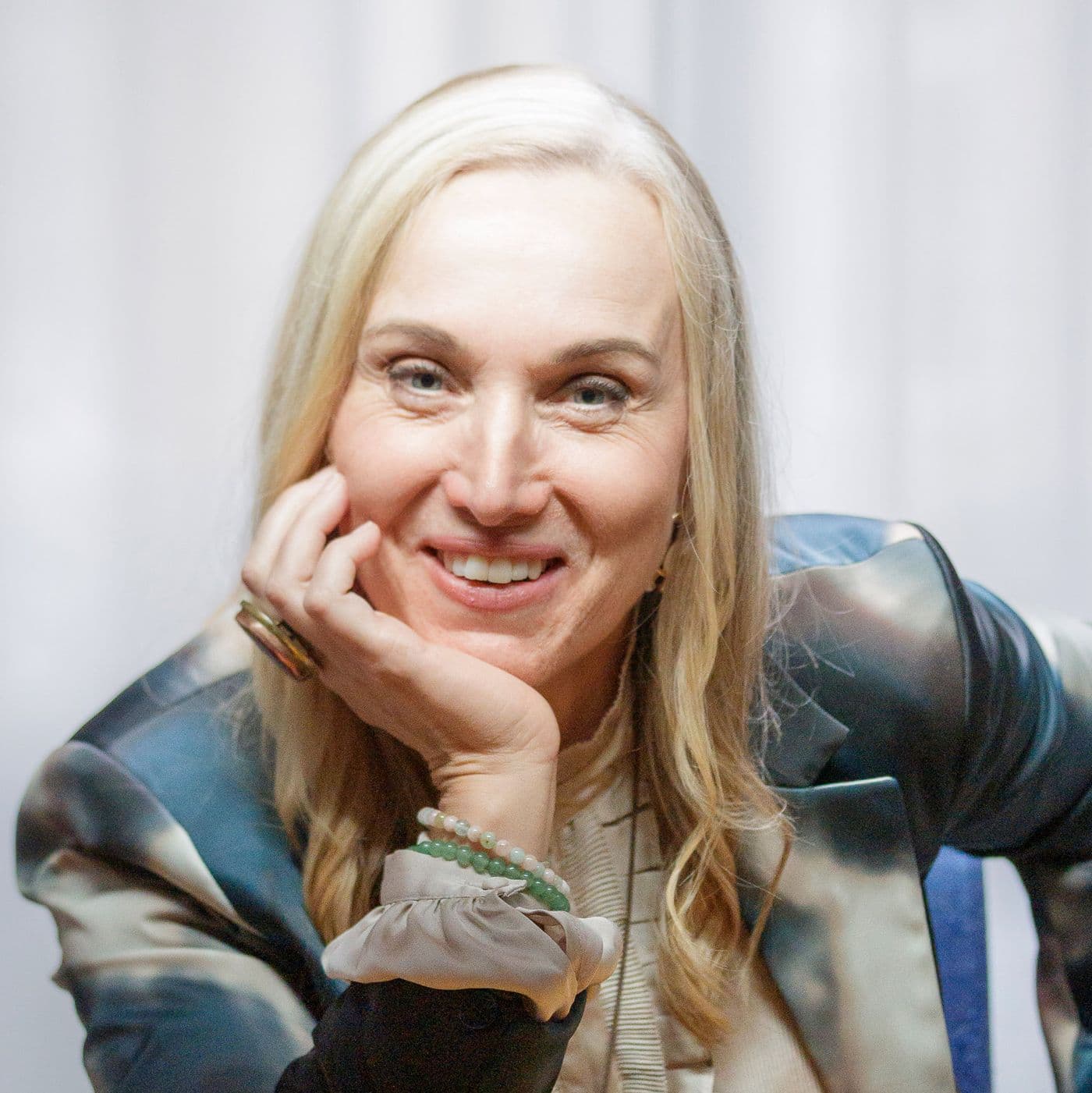 Helene's headshot: smiling, chin on her hand, in the room where she was interviewed