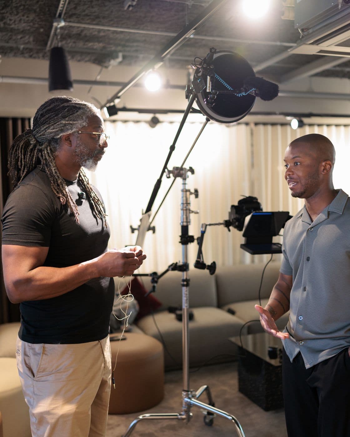 Kevan and Undray face to face on set, Undray mid-sentence with his hands open, a light and a teleprompter on stands behind them, May 2026