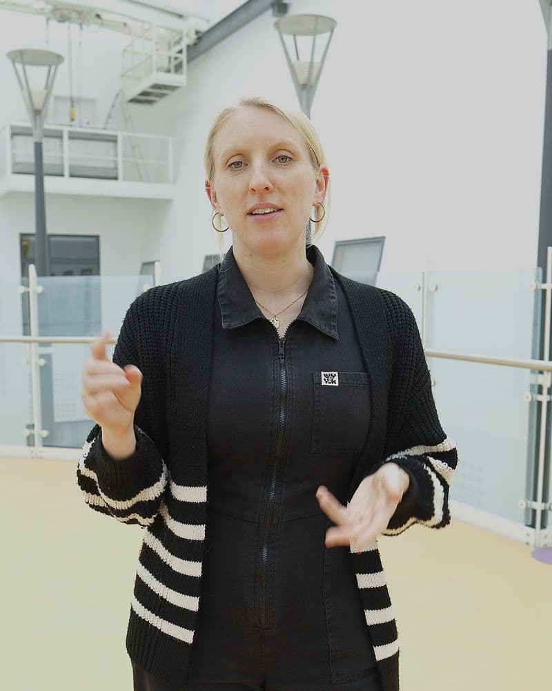 Emma speaking in the hospital's glass-roofed atrium